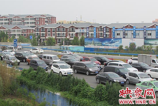 記者看到鄭州機場收費站口車輛排隊，與此形成鮮明對比的是，路的對面（另一半幅）卻車輛較少，通行順暢。