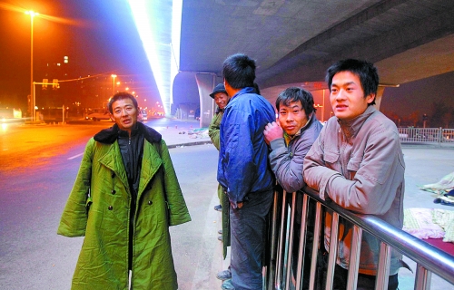 冬夜里，農(nóng)民工在橋下等著干活兒。