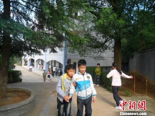 4年來，13歲的余興泉（左一）每天都攙扶著腿腳不便的同學(xué)左臣進出教室、食堂和廁所。 李俊杰 攝