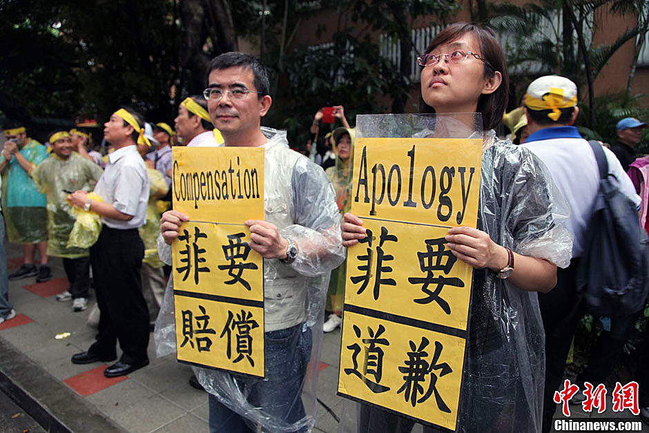 　圖為當(dāng)天下午，當(dāng)臺灣數(shù)百漁民在馬尼拉經(jīng)濟(jì)文化辦事處前抗議時，有兩名年輕人手持標(biāo)語，在路邊聲援。中新