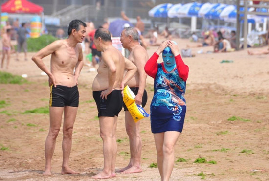 2013年7月3日，山東青島青島高溫來襲，“青島大媽”不懼滸苔，戴著“強盜面具”出現(xiàn)在海水浴場消暑降
