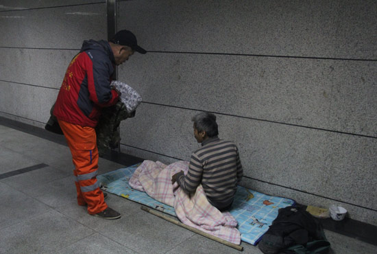 在鄭州一處地下通道，孫德坤挑了幾件衣服送給了流浪者