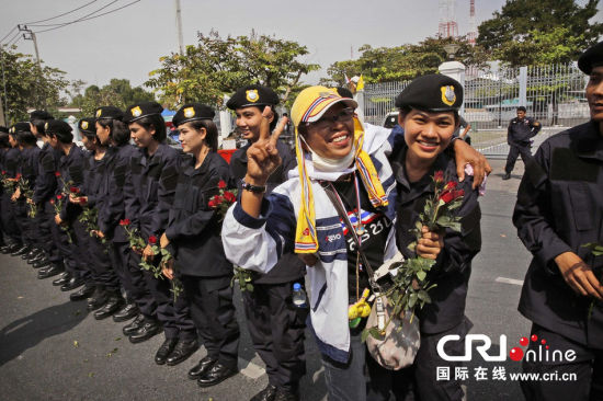 2013年12月03日,曼谷總理府與曼谷警署允許反政府示威民眾進(jìn)入,雙方進(jìn)入暫時(shí)“停戰(zhàn)”狀態(tài)迎接泰王生日。曼谷警察總署,女警們手持鮮花送給反政府示威民眾。圖片來(lái)源:Manish Swarup/東方IC