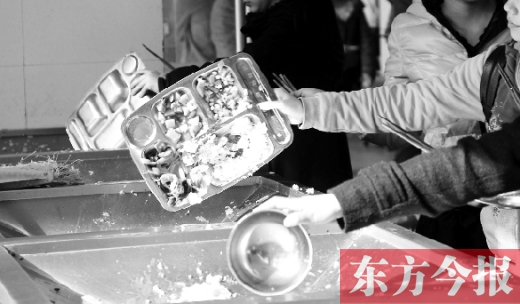 11月27日，河南中醫(yī)學(xué)院餐廳，一名同學(xué)將餐盤內(nèi)沒(méi)吃完的食物倒入餐具回收車內(nèi)