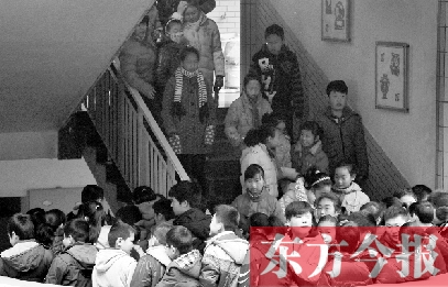 　某小學(xué)的學(xué)生走下樓梯放學(xué)。
