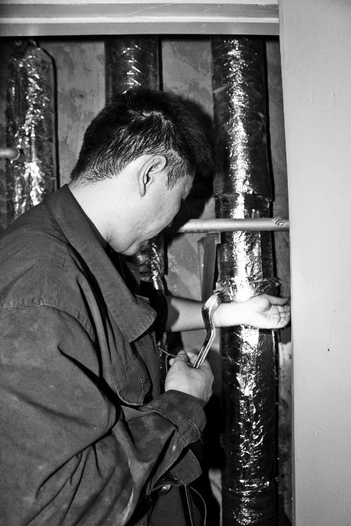 苗師傅一邊進(jìn)行維修，一邊用耳機(jī)接聽市民的電話。