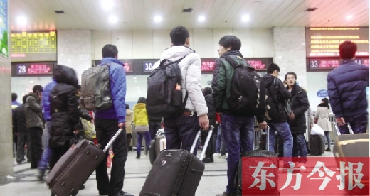 鄭州火車站東廣場售票大廳，幾名學(xué)生在售票窗口前躊躇