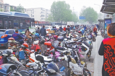 省人民醫(yī)院北門，路邊的公交站牌處停滿非機動車，上、下客只能在快車道上。
