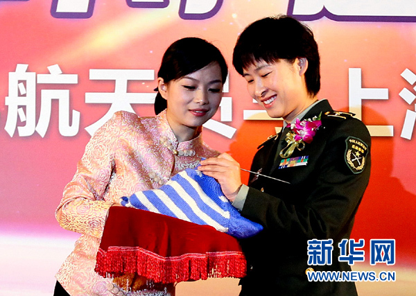 11月1日，航天員劉洋（右）在為“愛心”毛衣編織最后的收尾針。