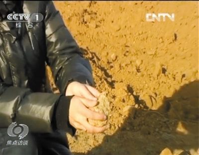 麻剛沙系麻剛石粉碎而成。記者找到一塊麻剛石，一捏就碎成粉末，硬度非常差。央視截圖