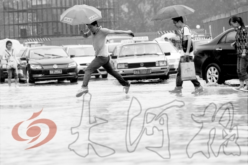 鄭州經(jīng)三路與北環(huán)交叉口處，積水較深，行人們不得不“練輕功”。 記者 白周峰 攝影