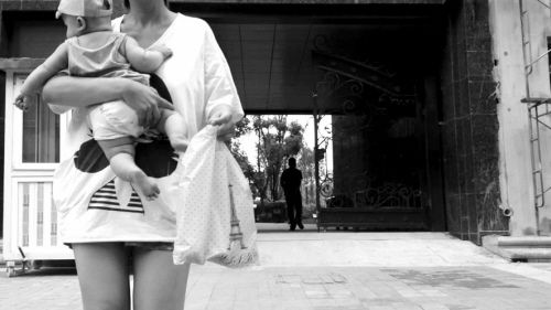 抱著孩子出售人奶的女子。