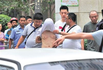 昨日，成都警方抓捕時與毒犯發(fā)生槍戰(zhàn)。一名男犯罪嫌疑人被警方押出。