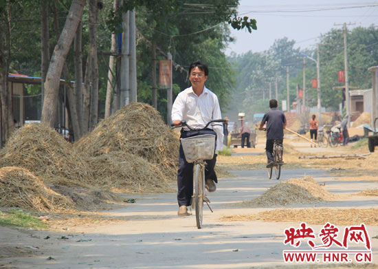 圖為王格現(xiàn)騎著自行車去學(xué)校。
