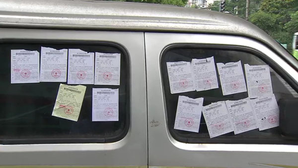 面包車(chē)上滿滿貼了14張罰單。