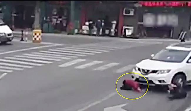 圖為小姑娘被卷進(jìn)車輪下瞬間。