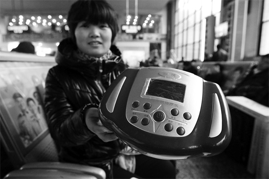 火車站候車室，李女士向記者展示她準備孝敬父母的按摩儀