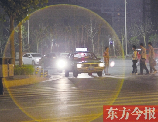 昨晚，鄭州火車東站，一些出租車停靠在路邊，見到行人不時主動搭訕 東方今報暗訪組 攝