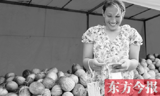 昨日，開封瓜農(nóng)史瑩瑩幸福地數(shù)著賣瓜錢 東方今報記者 沈翔 攝