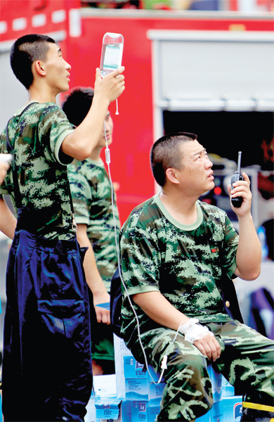 火場外，被消防戰(zhàn)士稱為“李大隊”的救援人員掛著吊瓶現(xiàn)場指揮