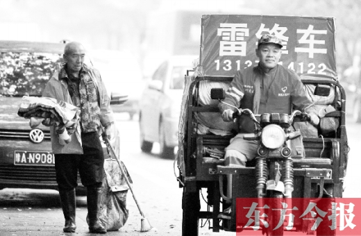 鄭州市商城路，一名環(huán)衛(wèi)工懷抱著剛剛收到的毯子，目送“雷鋒哥”孫德坤離開