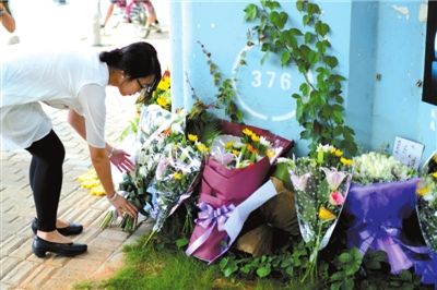 6月8日下午，記者來到廈門公交車爆炸事發(fā)現(xiàn)場橋下，附近已聚集了十幾個(gè)自發(fā)前來悼念的市民。橋墩下排放了一圈或黃或白的菊花，還有玖瑰、百合等。