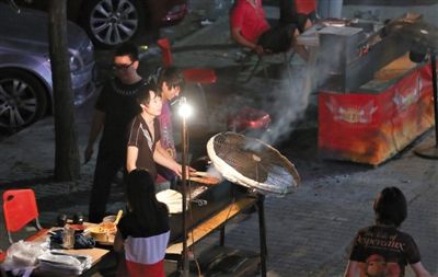 7月4日，青年路國美第一城小區(qū)附近的夜市臨街露天燒烤攤。