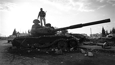 9月8日，敘利亞Zabadani，一名敘利亞反對派武裝人員站在廢棄的政府軍坦克上。