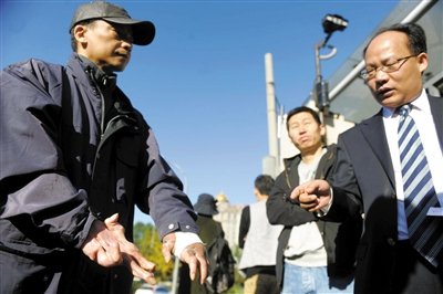 常林鋒在法院外展示雙手，他稱被燙傷的手因刑訊逼供且未得到及時(shí)救治