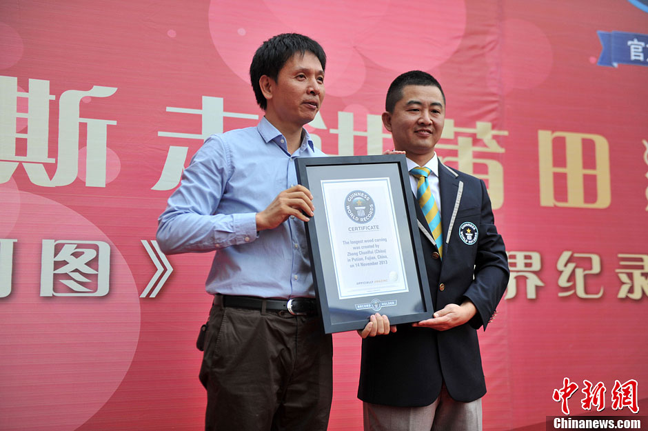 圖為世界吉尼斯認(rèn)證官為鄭春輝（左）頒發(fā)證書。呂明 攝