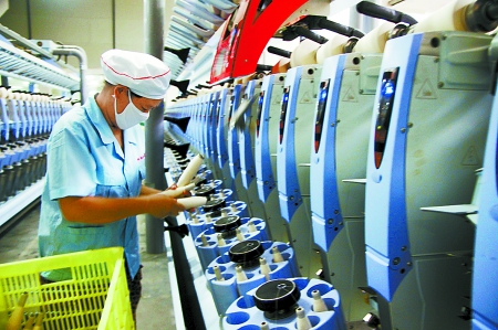 7月3日，在鄧州市永泰棉紡有限公司電腦控制全自動紡紗車間，紡織工人正在生產(chǎn)棉紗。