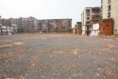 為降塵，旮旯王村拆遷后裸露的地面上鋪了一層石子。