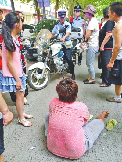 在鄭州優(yōu)勝南路東三街交叉口向東100米處，一名短發(fā)中年女子平躺在路南快車道上，身旁還有一只掉落的拖鞋