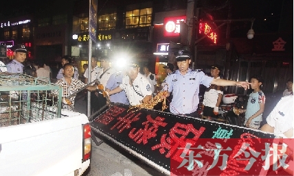 7月8日晚，鄭州市商城路一家占道經營的攤販招牌被執(zhí)法隊員“登記保存”