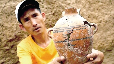 　　考古工作人員展示出土的仰韶文化時(shí)期代表性彩陶。