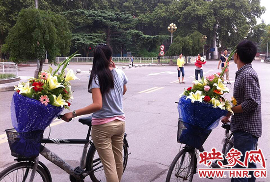 在鄭州大學(xué)南校區(qū)，有不少學(xué)生三五成群，手捧鮮花。