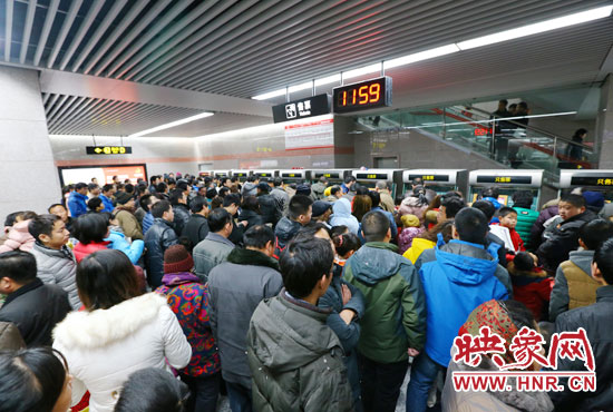 地鐵開通首日，上午十一點五十九分，紫荊山地鐵站售票機前擠滿了買票的市民。