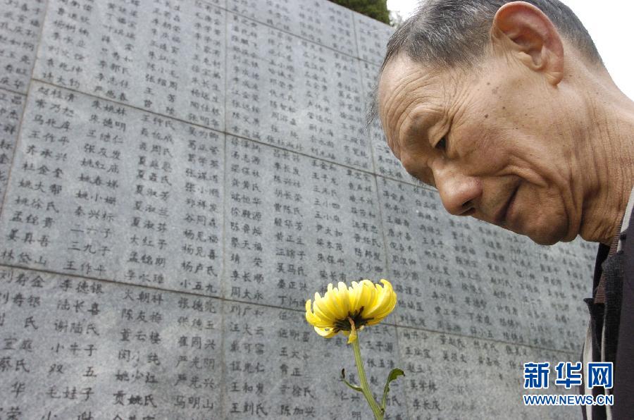 2006年4月5日，74歲的南京大屠殺幸存者佘子清手捧鮮花，祭奠被日軍殺害的母親。