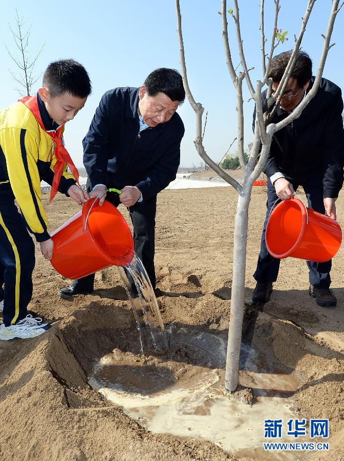 這是習(xí)近平同大家一起給剛栽下的樹苗澆水。