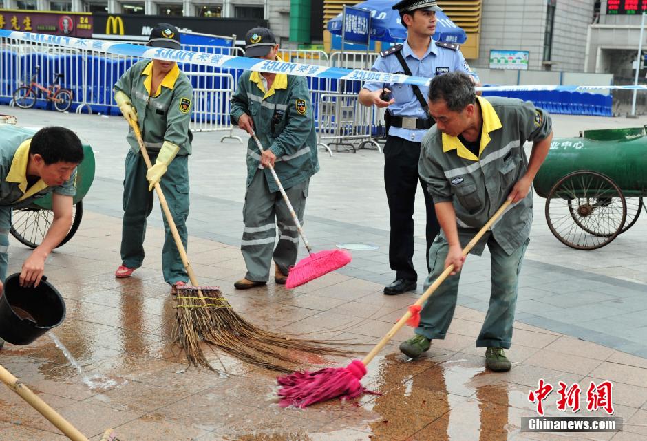圖為環(huán)衛(wèi)工人在清理案發(fā)地點的血跡。