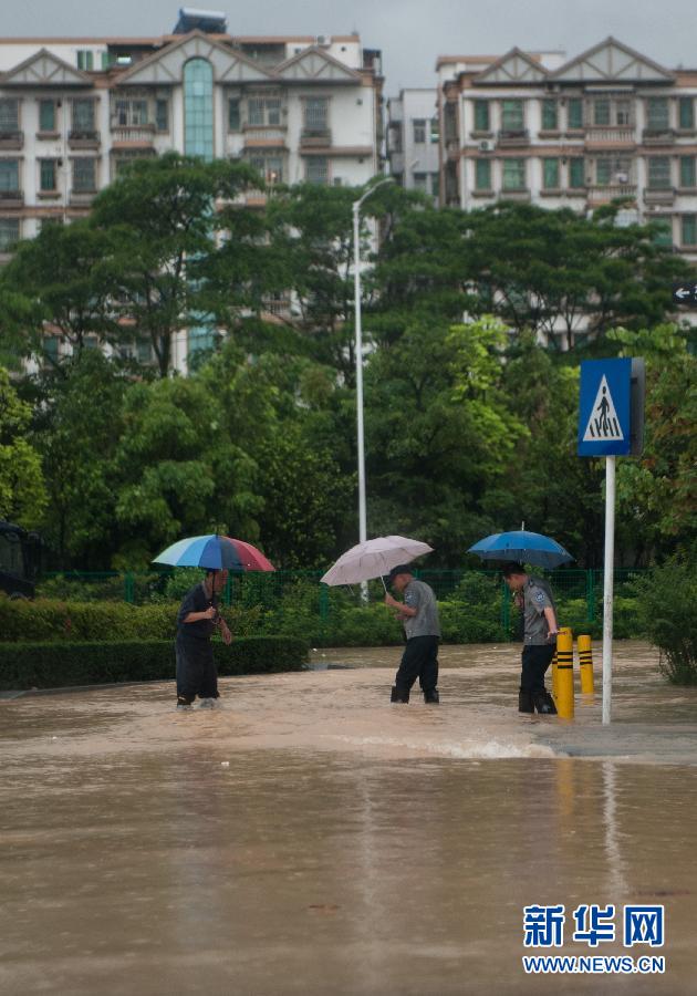 5月11日，人們在深圳西麗涉水行走。