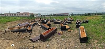 40多副棺木被砸壞后，扔在荒地上。