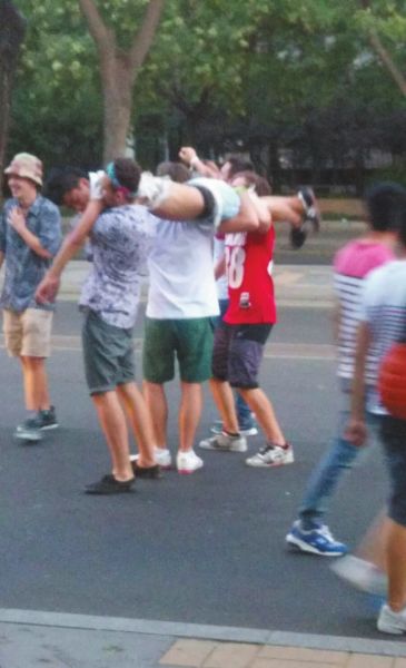 　四名外籍男子一同扛起醉漢拍照。