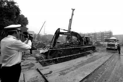 學(xué)院南路一科研樓項目有3臺挖掘機(jī)違規(guī)進(jìn)行土方作業(yè)，被城管隊員當(dāng)場責(zé)令停工。京華時報記者歐陽曉菲攝