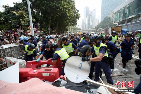 10月14日，警方清除金鐘道障礙物。大批警員在金鐘道現(xiàn)場(chǎng)清拆障礙物。部分警員戴上頭盔將障礙物移走。
