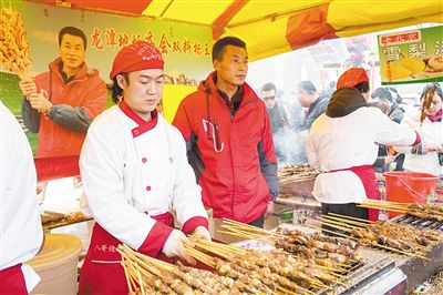 賣羊肉串?dāng)偽焕习遐w山（穿紅衣者）。新京報(bào)記者