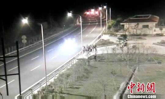 看到車輛經(jīng)過，孩子們便急忙跑到一旁的花圃上?！【焦﹫D　攝