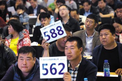 昨日，拍賣現(xiàn)場競拍者舉牌競拍。新京報記者