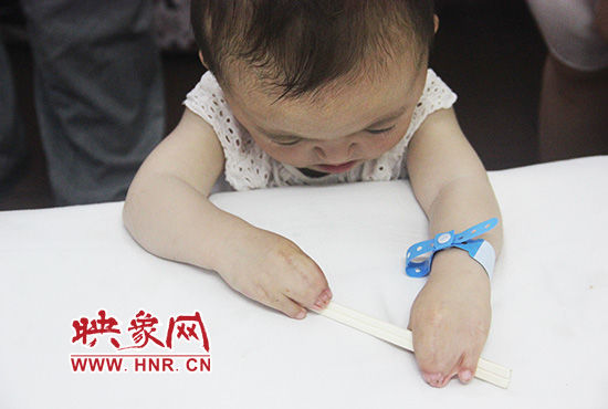 孩子握著筷子發(fā)呆。