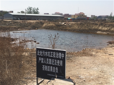 化肥廠滲坑的三分之一經(jīng)過治理，但水質(zhì)仍然呈黃褐色。